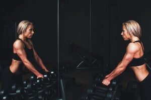 Mulher na academia olhando no espelho