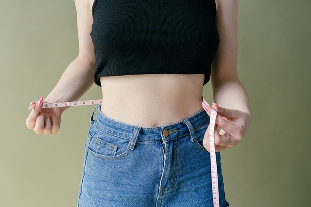 Imagem ilustrativa mostrando uma mulher magra usando uma fita métrica