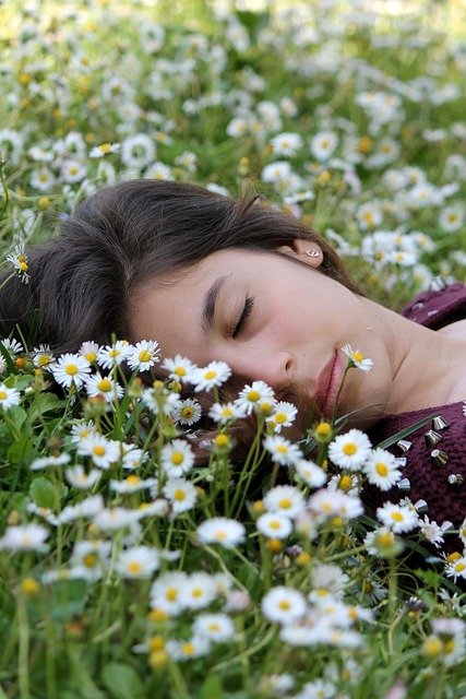 Mulher dormindo num campo cheio de flores